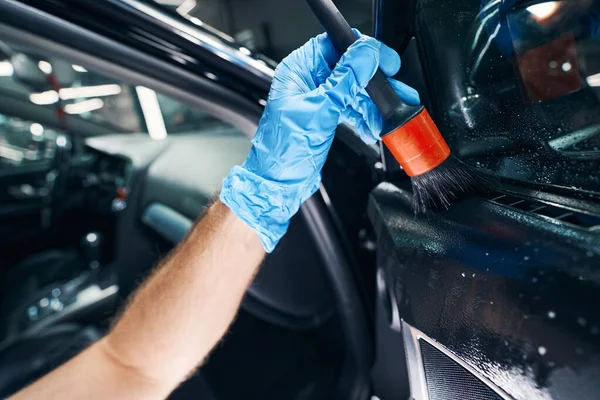 Detergente de limpieza de esparcimiento masculino en la ventana del coche con cepillo — Foto de Stock