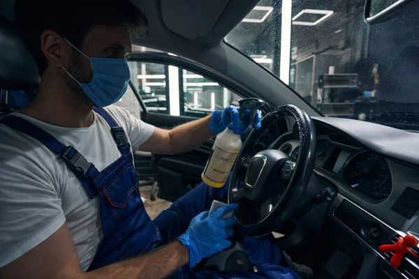 Trabajador lavado coche volante con spray de limpieza — Foto de Stock