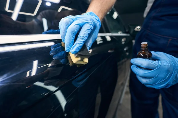 Trabajador con aplicador de microfibra que extiende recubrimiento de cerámica en el coche —  Fotos de Stock