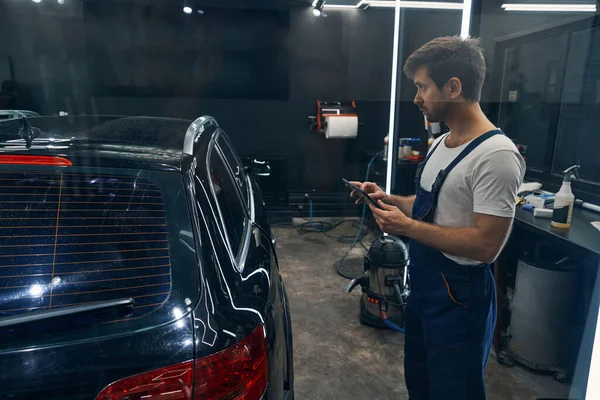 Auto tekniker med tablett studerar bil efter att ha detaljerat — Stockfoto