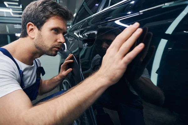 Male auto mechanic inspecting surface of car — Stock Photo, Image