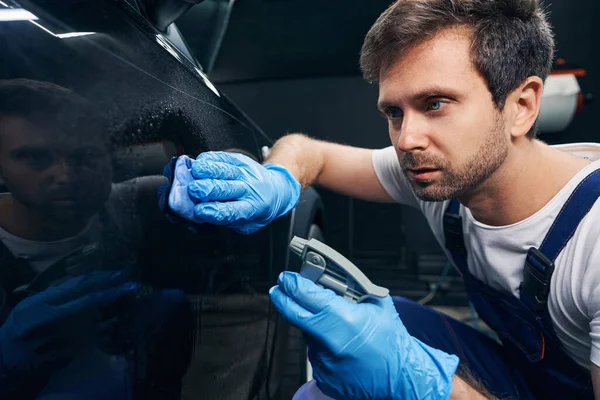 Mannlig arbeider avfettet autokropp med væske og tørkestoff – stockfoto