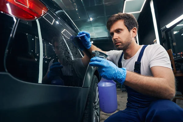 Réparateur de voiture saupoudrer la surface de la voiture avec du liquide — Photo