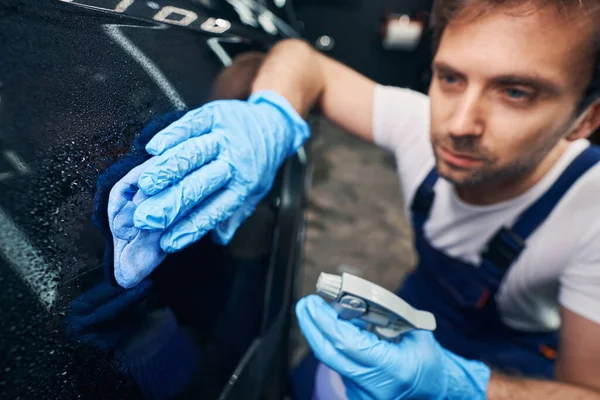 Automotive repairman cleaning car from degreaser with rag — Stock Photo, Image