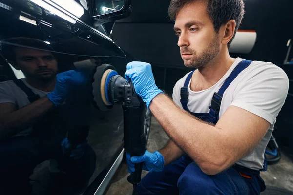 Reparador de automóviles restaurando la carrocería del coche con pulidor —  Fotos de Stock