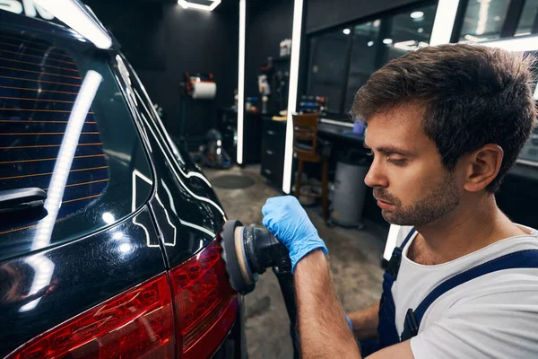 Técnico taller de reparación de automóviles lijado luces traseras del coche —  Fotos de Stock
