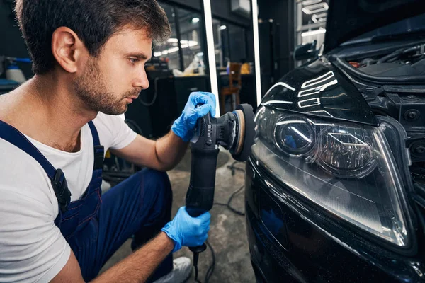 Masculino reparador automotivo polimento carro luzes dianteiras — Fotografia de Stock