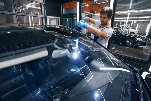 Técnico masculino del coche que trabaja en la superficie del roor con el pulidor —  Fotos de Stock