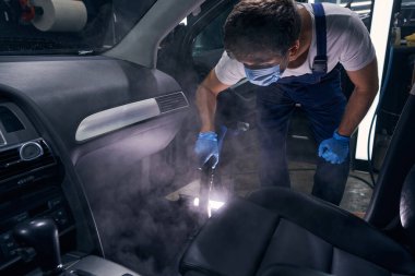 Kimyasallarla güvenlik maskesi temizleme otomobil tamircisi.