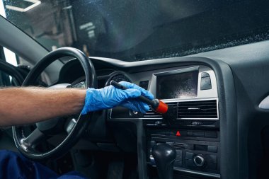Araba salonundaki havalandırma ızgaralarını temizleyen işçilerin eli