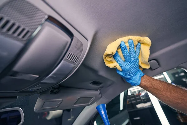 Pracovník čistí chemikálie z automobilového stropu — Stock fotografie