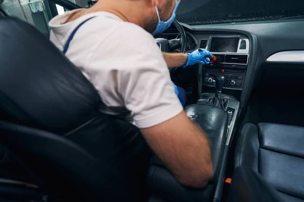 Técnico masculino escovando a sujeira do painel do carro — Fotografia de Stock