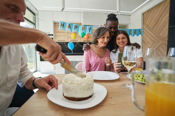 Чоловік ріже торт на вечерю на день народження — стокове фото