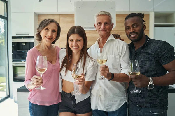 Familia sosteniendo vasos de bebida y posando en cámara — Foto de Stock