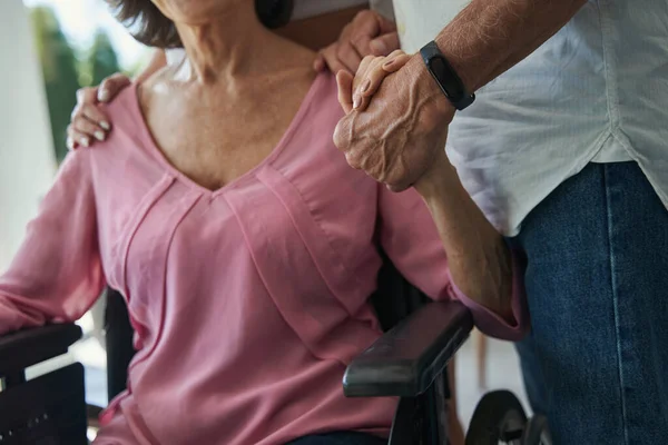 Familieleden die vrouwelijke personen met een lichamelijke handicap ondersteunen — Stockfoto