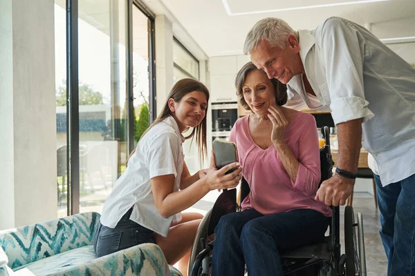 Kvinna med funktionshinder tittar på mobil med intresse — Stockfoto