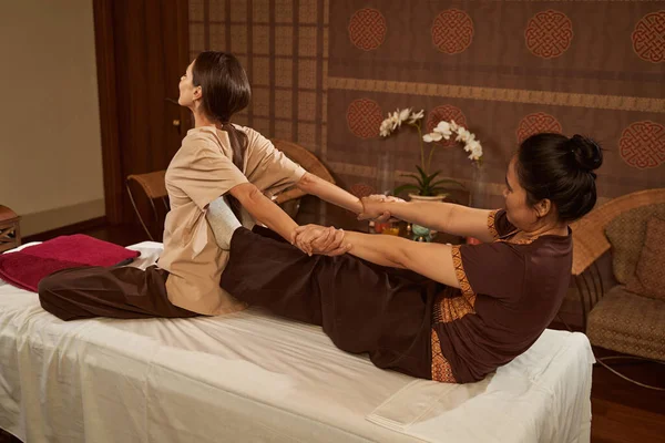 Therapist performing seated arm and shoulder stretch on patient — Stock Photo, Image