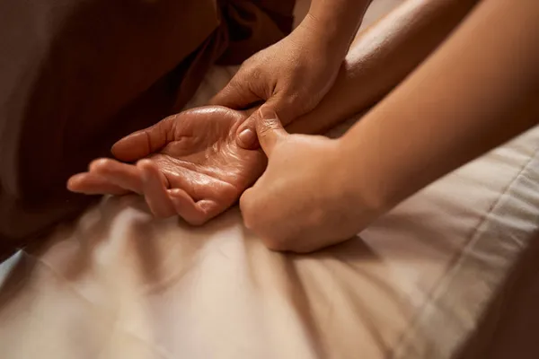 Massage therapeut stimuleren reflex punt op client hand — Stockfoto