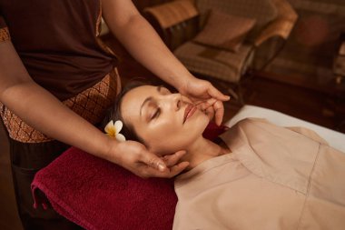 Kadın masajcı müşterisine akupunktur masajı yapıyor.