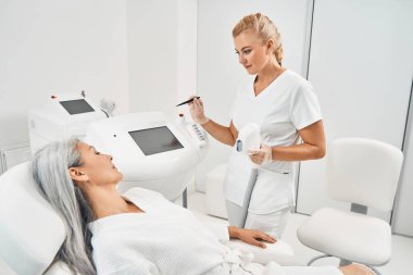 Nazik kuaför lazer saç çıkarıcı hazırlıyor.