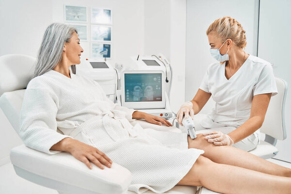 Удовлетворенный седой пациент, смотрящий на экран во время процедуры