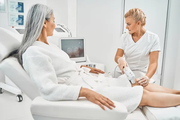 Attentive female person looking at screen during epilation — Stock Photo, Image