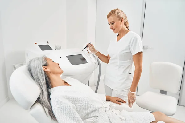 Attentive patient listening to her beauty master — Stock Photo, Image