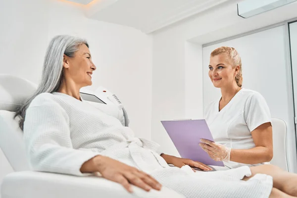 Encantadora mujer asiática mirando a su maestro de belleza — Foto de Stock