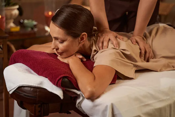 Young beauty salon customer having her back massaged — Stock Photo, Image