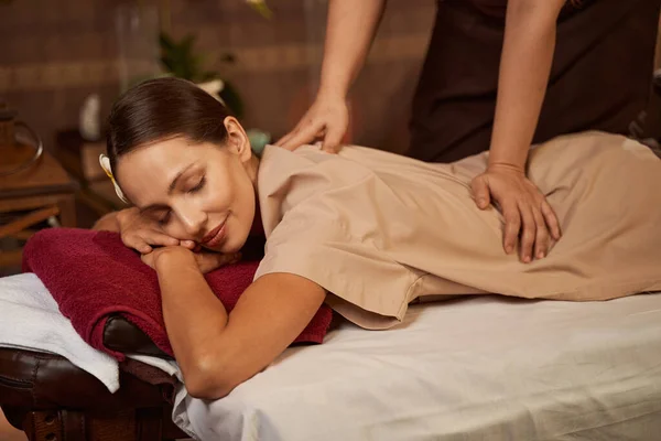 Señora tranquila recibiendo su espalda masajes en el salón de spa — Foto de Stock