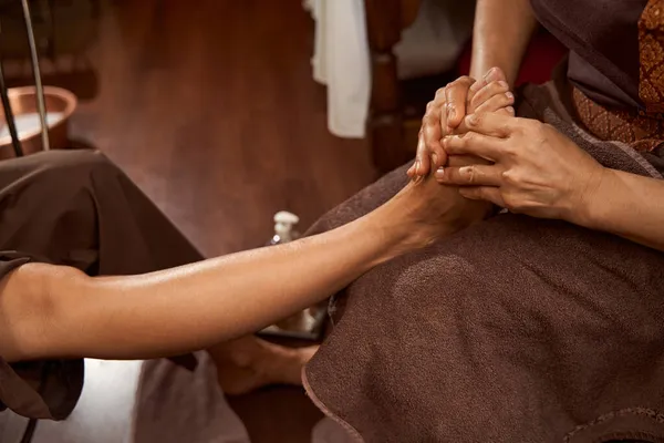 Masseuse giving her client Thai leg massage — Stock Photo, Image