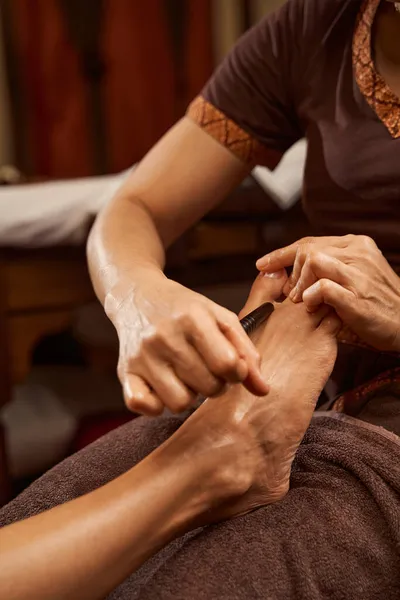 Masseuse stimulerend drukpunt op patiëntenvoet met houten gereedschap — Stockfoto