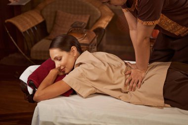 Kadın hasta psoas kasları üzerinde çalışan bir masoterapist.