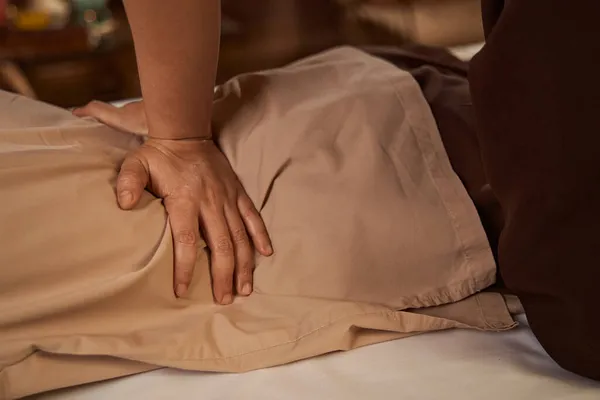 Practitioner using palm-pressing technique during Thai massage session — Stock Photo, Image