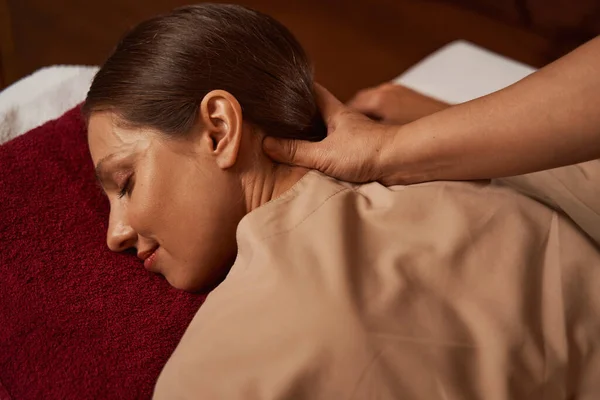 Pleased young woman dozing during spa procedure — Stock Photo, Image