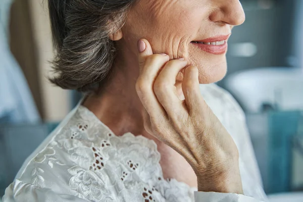 Hand van ouder wordende vrouw die haar gezicht aanraakt — Stockfoto