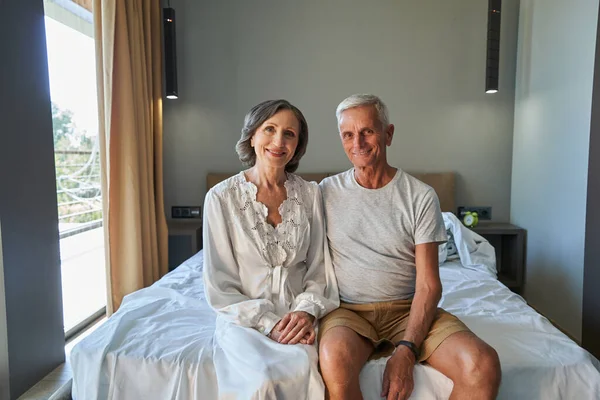 Casal de idosos sentados juntos em seu quarto — Fotografia de Stock