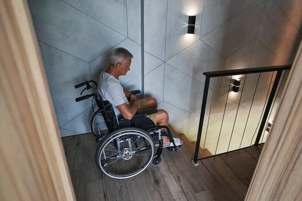Мужчина-инвалид-колясочник, у которого проблемы со спуском по лестнице — стоковое фото