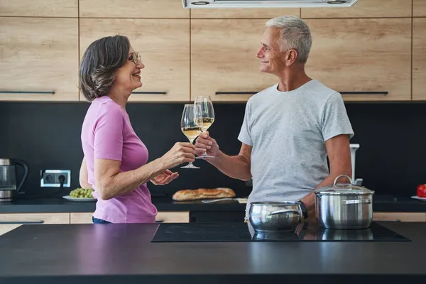 Casada pareja mayor bebiendo champán en la cocina — Foto de Stock