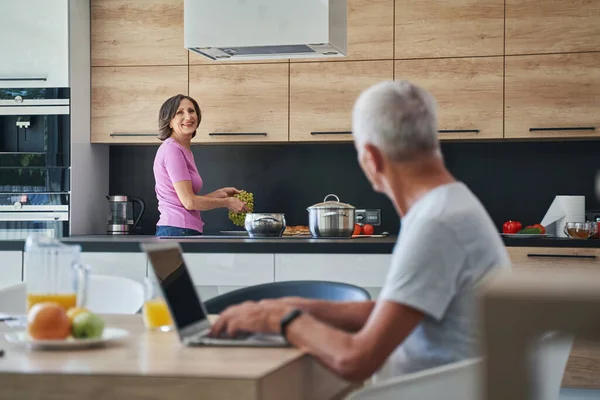 Koken vrouw kijken gelukkig op haar man — Stockfoto
