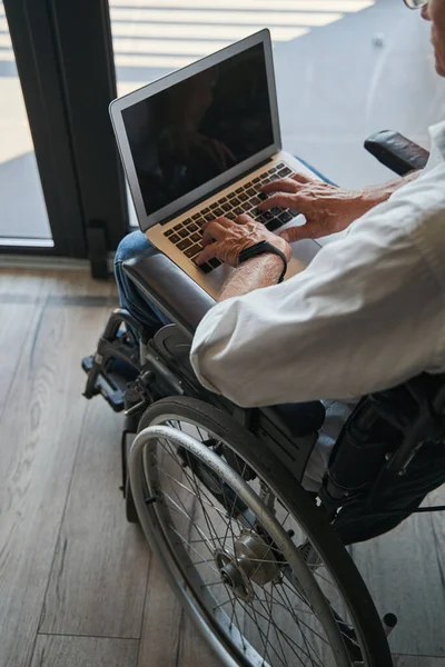 Pessoa com deficiência usando laptop de cadeira de rodas — Fotografia de Stock