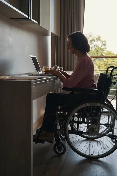 Mulher com deficiência trabalhando com laptop na mesa — Fotografia de Stock