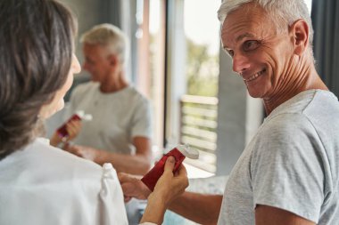 Emekli kadın diş macunu alırken şaşkınlıkla bakıyor.