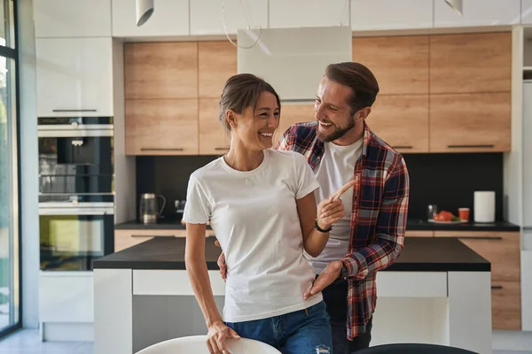 Hombre guapo y hermosa mujer disfrutando de momentos tiernos en la casa — Foto de Stock