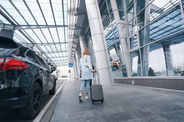 Teleskopik metal sapında el çantası taşıyan bir turist.