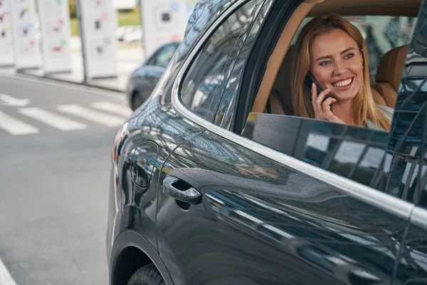 Радостная пассажирка, болтающая на смартфоне в машине — стоковое фото
