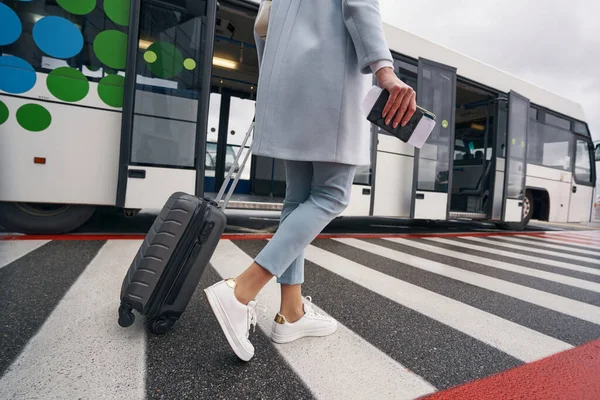 Nő poggyásszal és úti okmánnyal közeledik a reptéri transzfer buszhoz — Stock Fotó