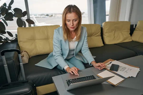 노트북 컴퓨터 앞에서 책상에 앉아 있는 여성 여행자 — 스톡 사진