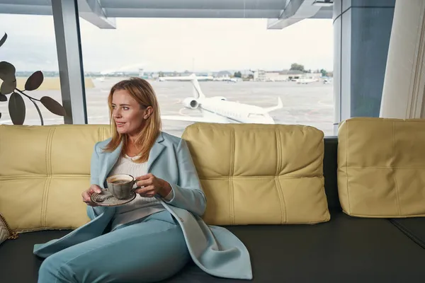 Femme agréable boire du café dans le salon de l'aéroport — Photo