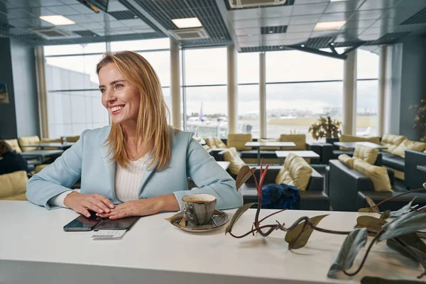 Высокомерная путешественница, сидящая в кафе аэропорта — стоковое фото